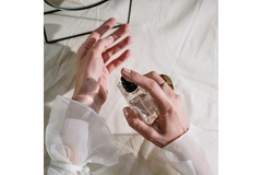 Image A hand spraying perfume on the other wrist.