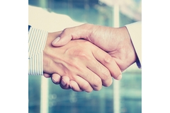 Two business people shake hands at the end of a deal.
