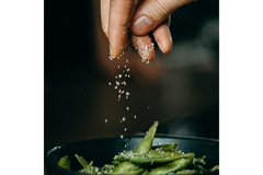 Sprinkling salt over edamame