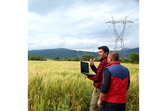 Image Two farmers in a wheat field with a laptop.