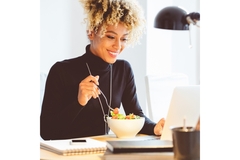Woman eating salad at her desk