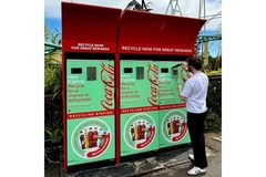 Image Man placing empty bottle in reverse vending machine.