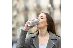 Image A woman drinking from a can.