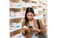 Image Woman inspects supplement label