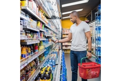 Image Man shopping for soft drinks in a supermarket.