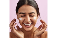 Image Happy woman with moisturizer smeared on her cheeks