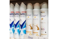 Image Dove deodorant spray cans on a shelt