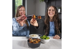 Image two girls holding cultivated meat.