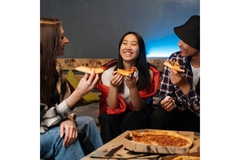 Image Teenagers eating a pizza.