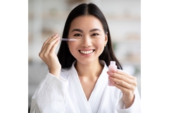 Image Asian woman applying eye serum.