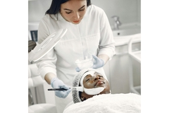 Image A dermatologist putting a face mask on her client.