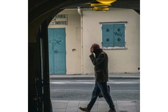 Image Man holds his head while walking