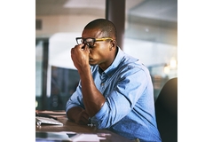 Image Stressed man holding a hand to his nose.