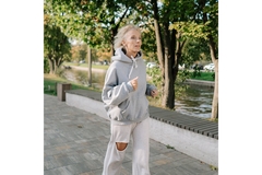 Image An older woman jogging along the beach.