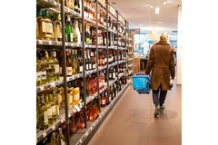 Image A person walking in a store with a basket.
