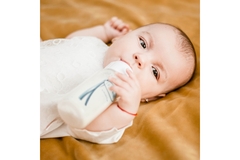 Image An infant drinking from a bottle.