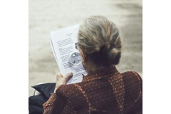 Woman reading with help of a magnifying glass
