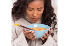 Woman eating a bowl of soup to help put her diabetes in remission.