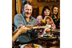 a man eating meat at the dining table.