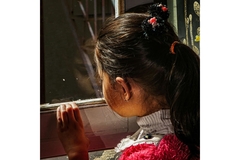 Image Afghan girl looks out of a window,
