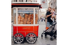 A family buying simit bread at a food cart.