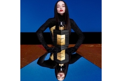model sitting behind perfume bottle
