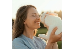 Image woman holds rabbit up to her nose smiling