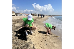 People wearing Aimplas hats cleaning a beach.