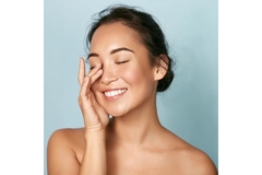 Image Woman smiles while touching her face