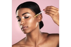 Image woman using a dropper to apply serum to cheek
