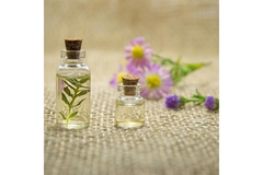 Image A small bottle of perfume with little flowers around it.
