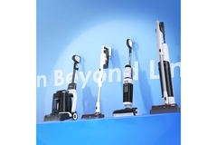 Image Three vacuums in a row in front of a blue backdrop.