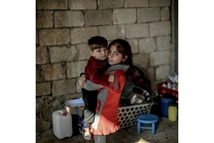 Image Big sister hold brother in Syria during conflict