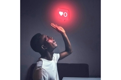 Image A man looking up at a glowing like button from Instagram.