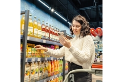 Image a girl looking at her phone in the supermarket.