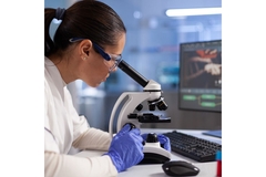Image Researcher looking through a microscope.