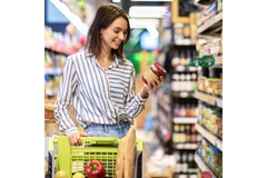 Image Woman in supermarket looks at product label