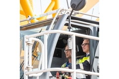 Two men in a construction vehicle.
