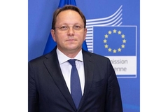 Image Olivér Várhelyiin suit in front of EC logo