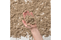 A hand holding a pile of fiber-based packaging waste