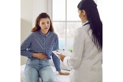 Image Woman with gut tumors talking to a doctor.