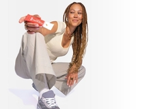 Image Woman in activewear holding up a Gatorade booster powder pack.