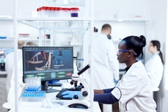 Image Scientists in a lab with one looking at a computer.