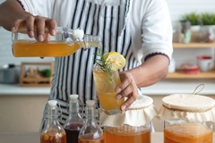 Image Person pouring a glass of kombucha.