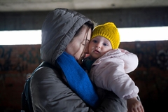 Image A mother clings to her baby during a disaster.