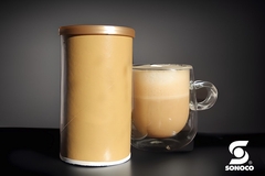 Image A cup and container with a brown liquid in it