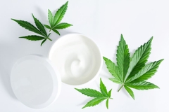 Image Cannabis leaves next to moisturizer jar
