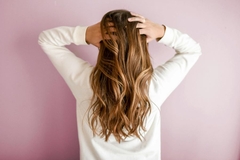 Image A woman running her fingers through her hair.
