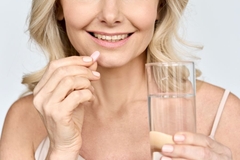 Image Woman takes collagen pill