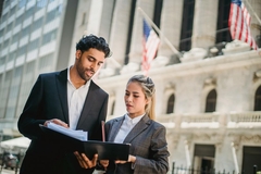 Image Two people standing on Wall Street.